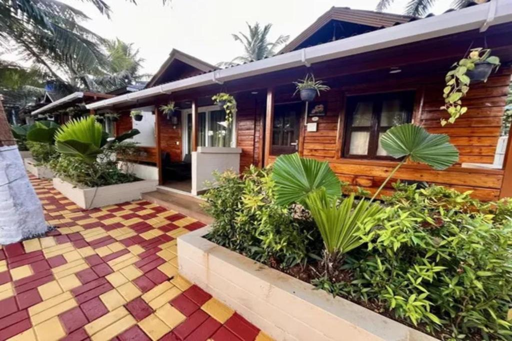 a house withtropical plants in front of it at FabHotel Maitree Beach Resort in Arambol
