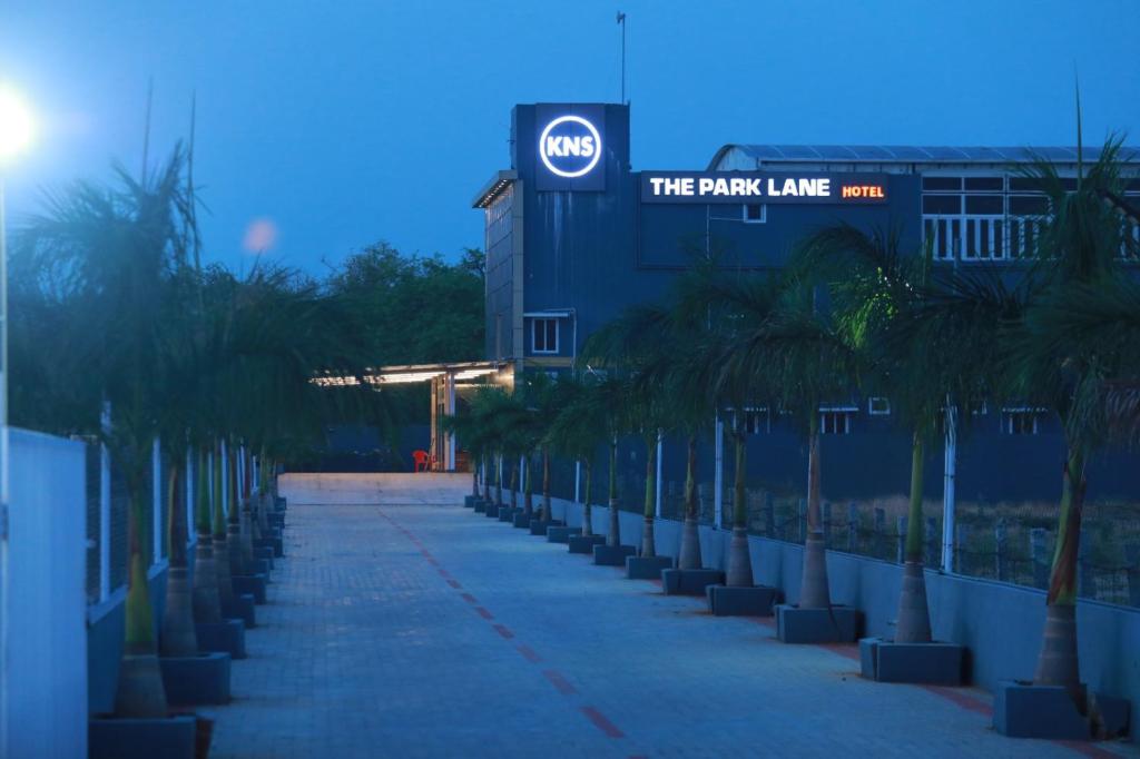 a row of palm trees in front of a building at The Park Lane Hotel in Krishnagiri