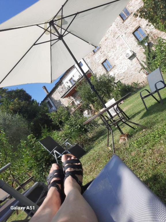 a persons feet in sandals sitting under an umbrella at casa delle arti in Salutio