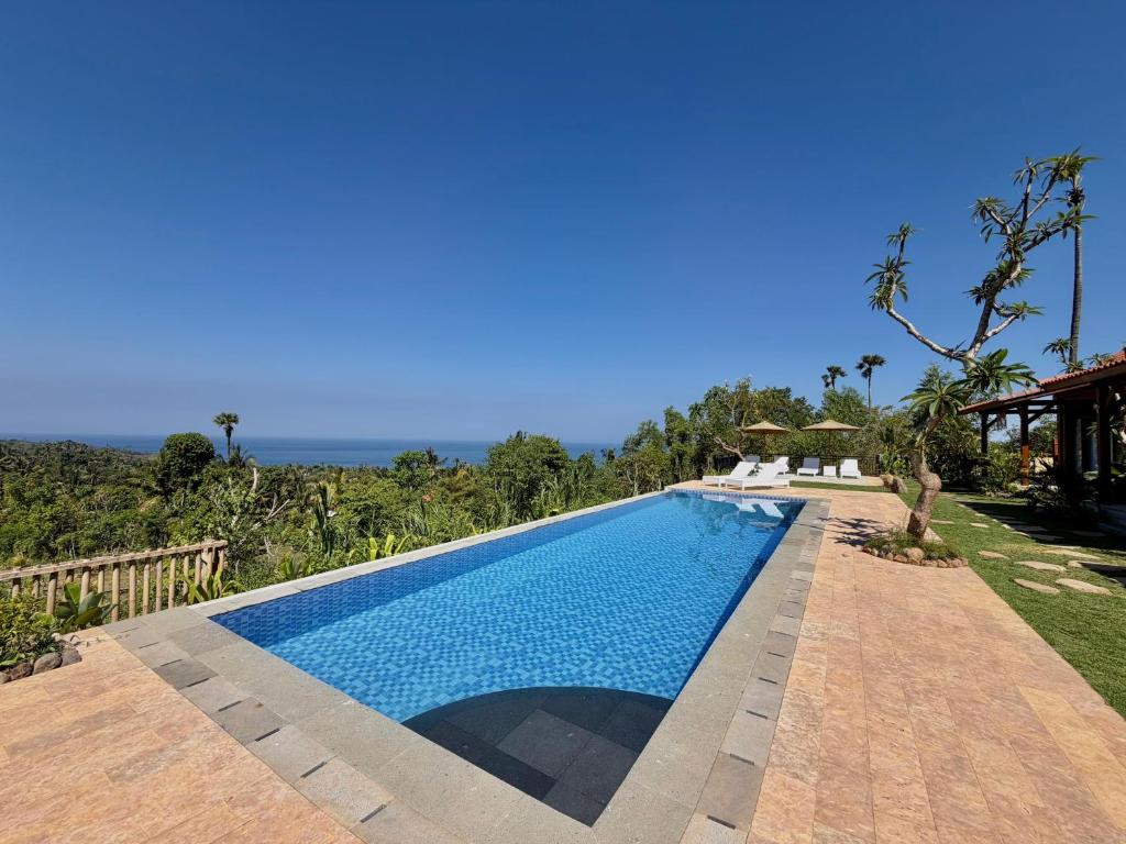 a swimming pool in front of a house at Atta Residence by Manara in Seraya