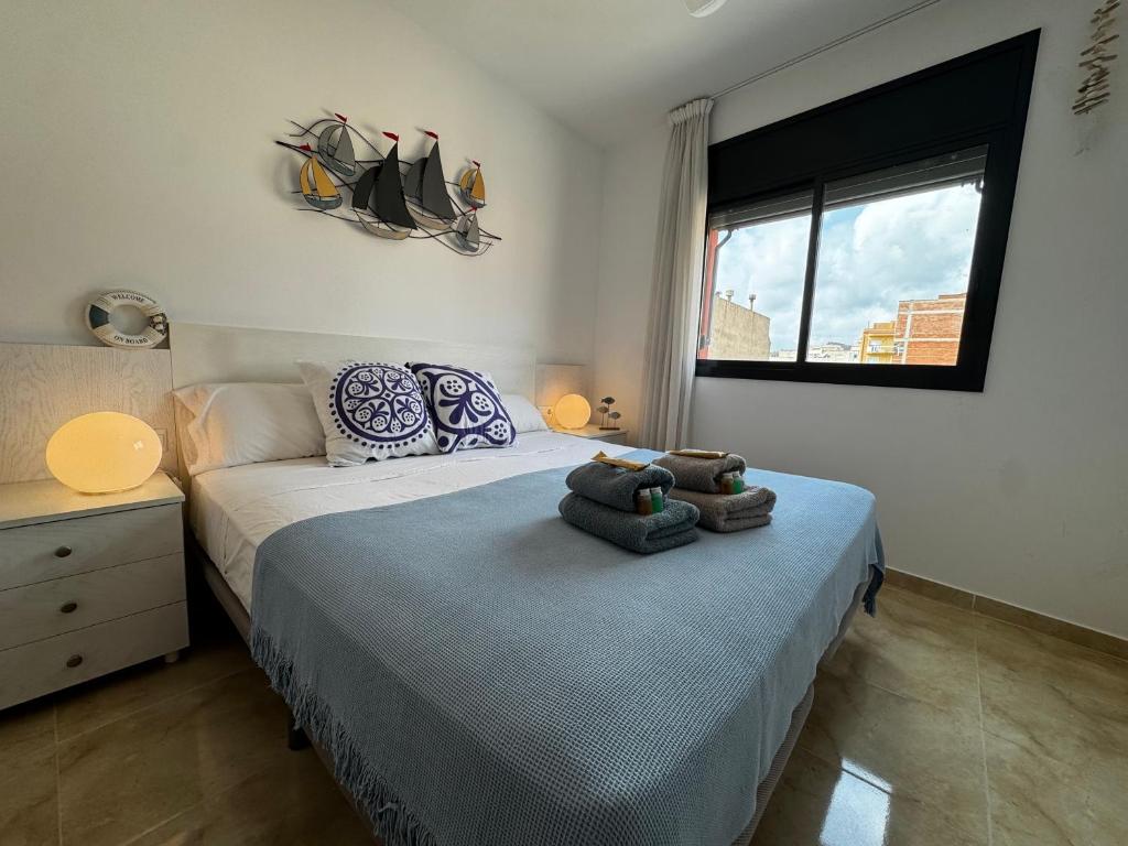a bedroom with a bed with towels on it at Repòs Mar i Muntanya in Perelló
