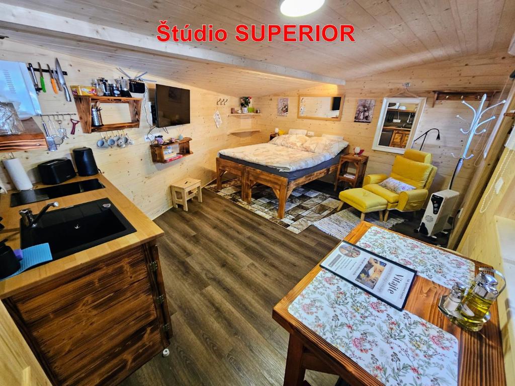 a room with a kitchen and a living room with a table at MK Apartment Karpaty in Zvončín