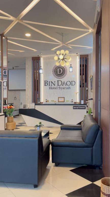a lobby of a hotel with two blue couches and a sign at BIN DAOD Hotel Syariah in Meulaboh