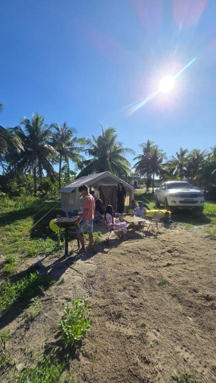 a man standing in front of a tent on the beach at Luxary Tent in Kudat