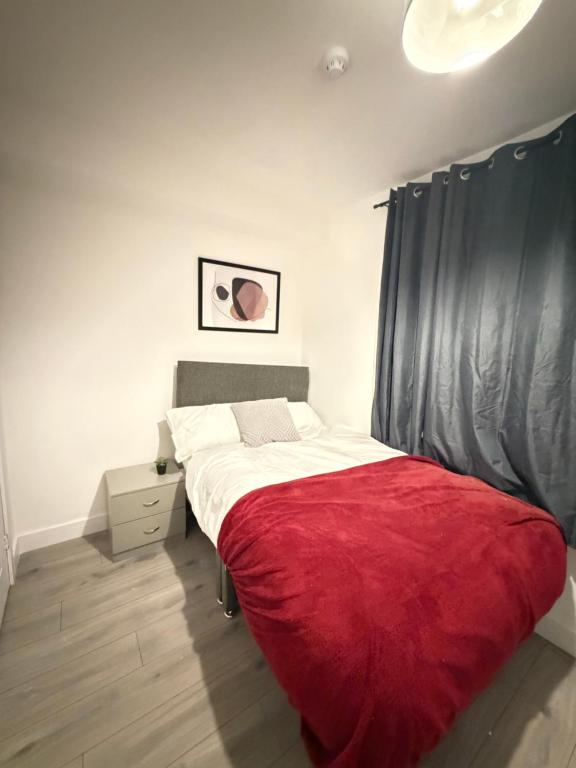 a bedroom with a large bed with a red blanket at Upton House in Chatham