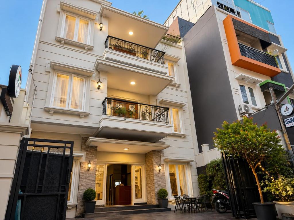 a white building with balconies on a street at Wisma Pelangi 5 in Jakarta
