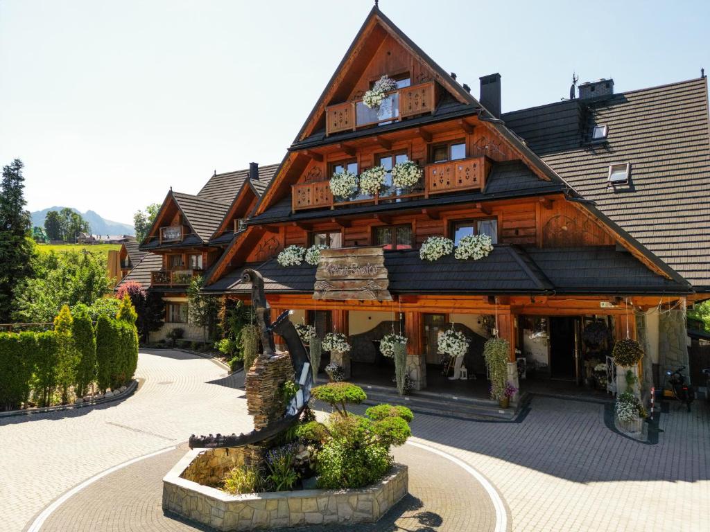 a large wooden building with plants in front of it at Kraina Smaku in Zakopane