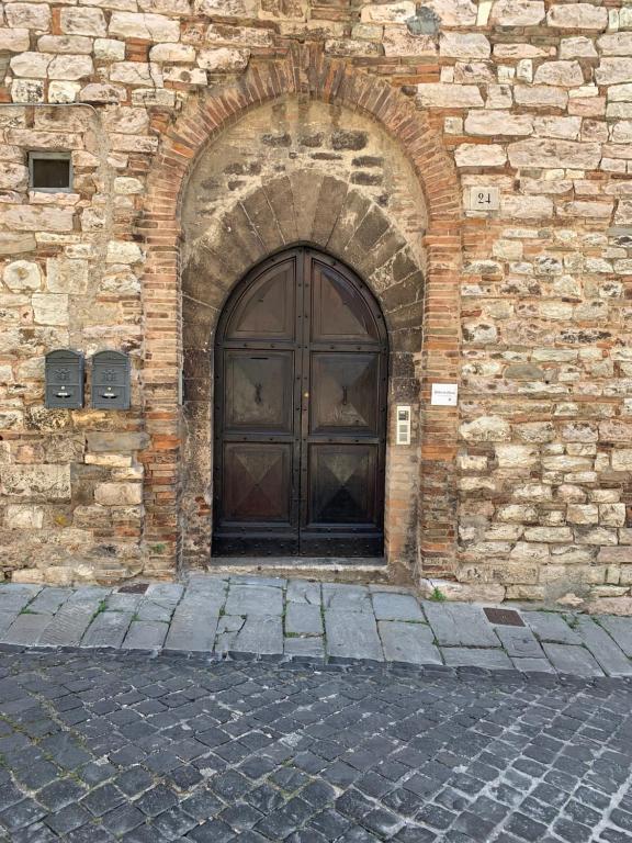 a large wooden door in a brick building at Palazzo Elisei in Gubbio