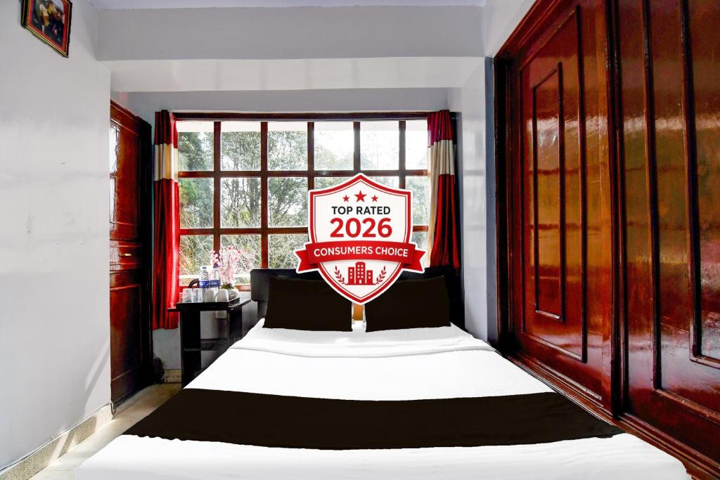 a bedroom with a bed with a sign that reads at Hotel O Ghoom Formerly Aps Homestay in Darjeeling