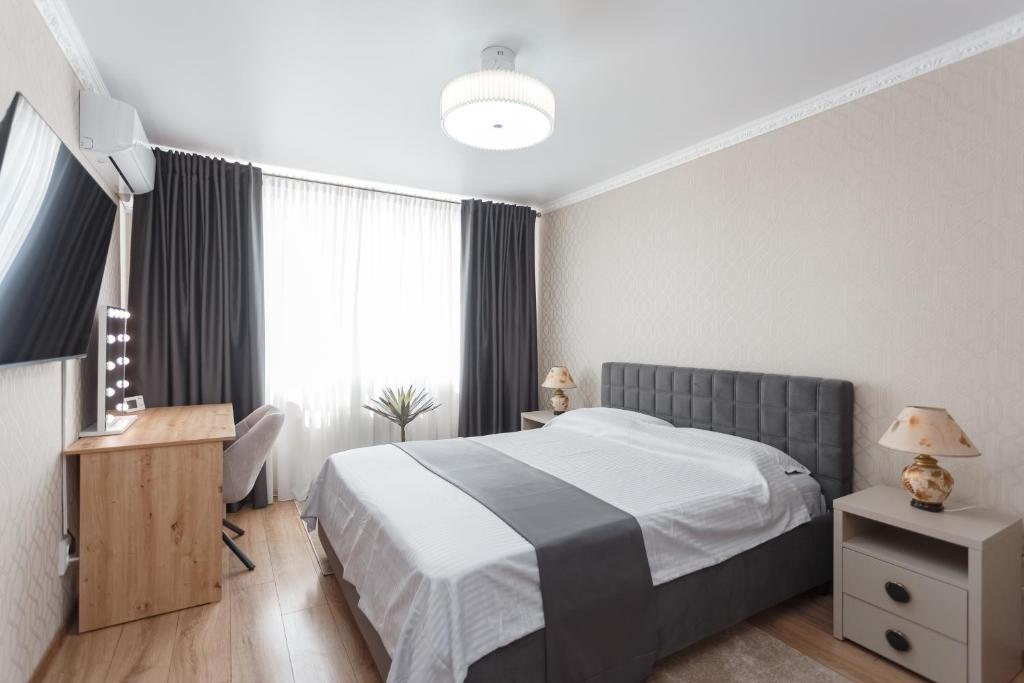 a bedroom with a bed and a desk and a window at Ion Creangă Residence in Chişinău