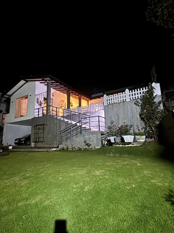a house with a fence and a yard at night at Villa Aureia in Bandarawela