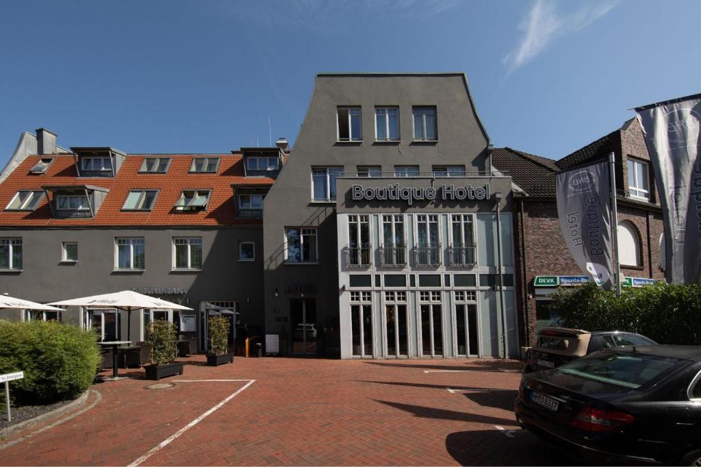 a building with a car parked in a parking lot at BHB - Boutique Hotel Buchholz in Buchholz in der Nordheide
