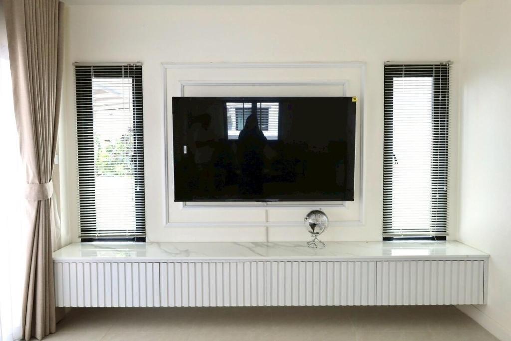 a living room with a large television in a window at Chiang Rai Home with Full Kitchen in Ban Pa Sang (1)