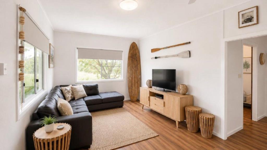 a living room with a couch and a tv at Surfside in Wooli