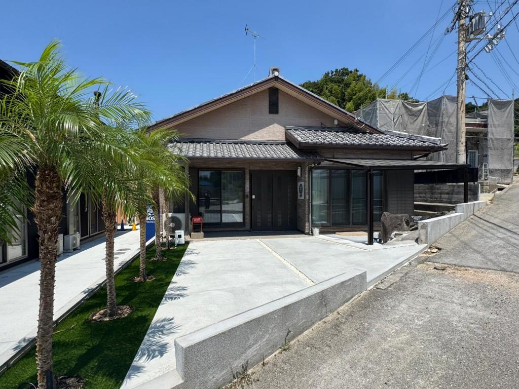 a house with a palm tree in front of it at Laina 31 in Sumoto