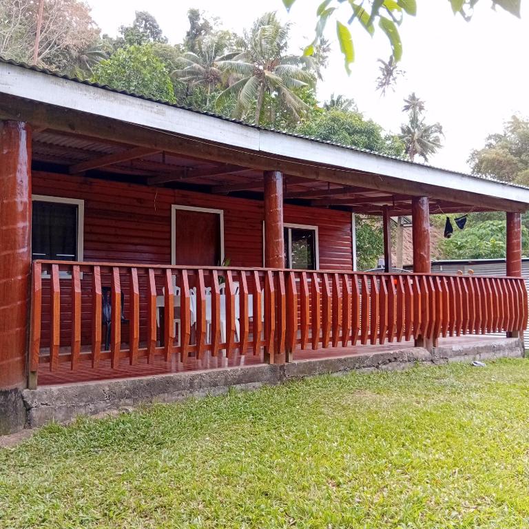 a wooden house with a fence in front of it at Pelly Homestay Adventure in Taveuni