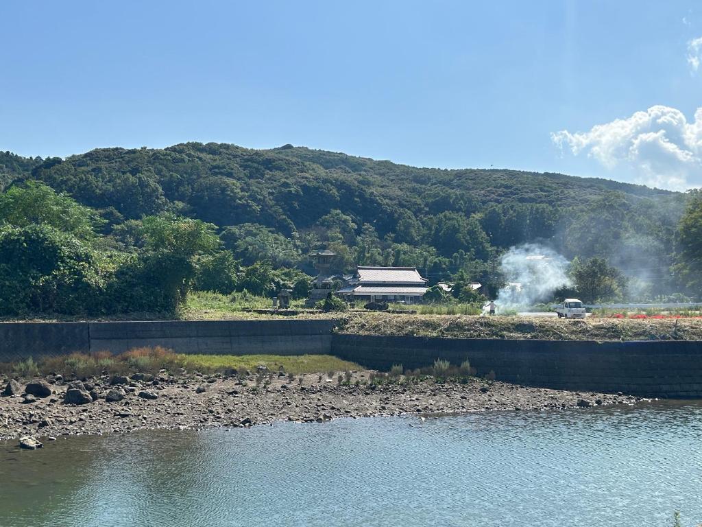 a bridge over a river with a building in the background at Kibe House in Kunisaki