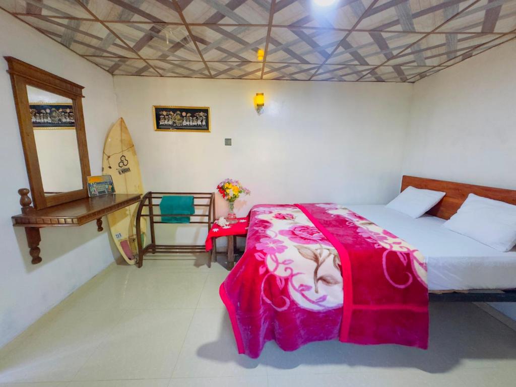 a bedroom with a bed and a table with a surfboard at Sana's homestay haputhale in Haputale