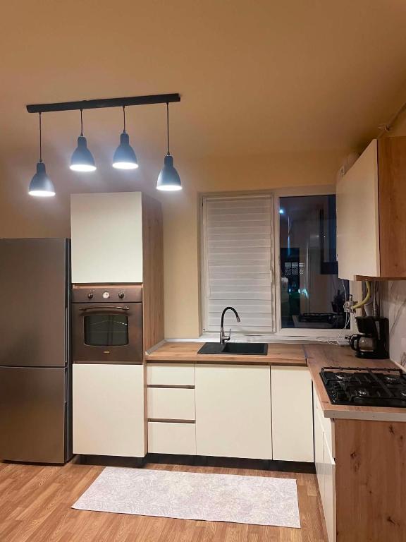 a kitchen with white cabinets and stainless steel appliances at Confort Apartament in Floreşti