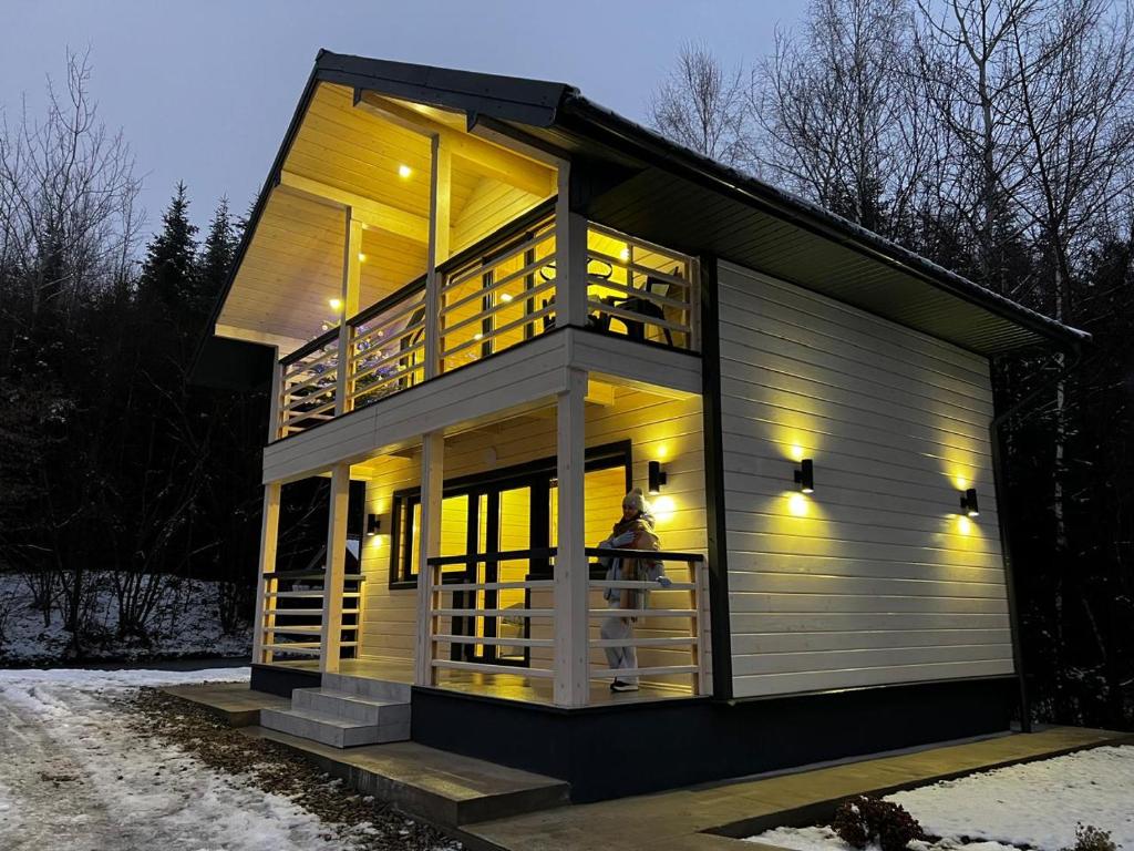 a house with lights on and a person standing in the window at InMonteHouse in Migovo