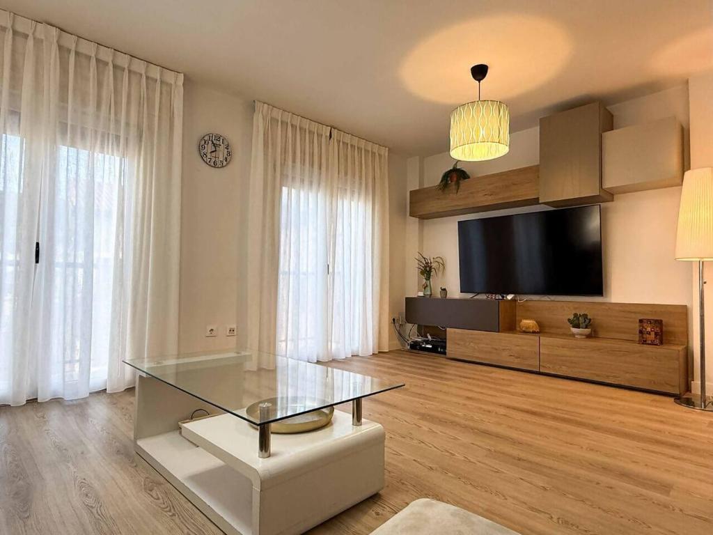 a living room with a glass table and a tv at Placituela 7 in San Esteban de Gormaz
