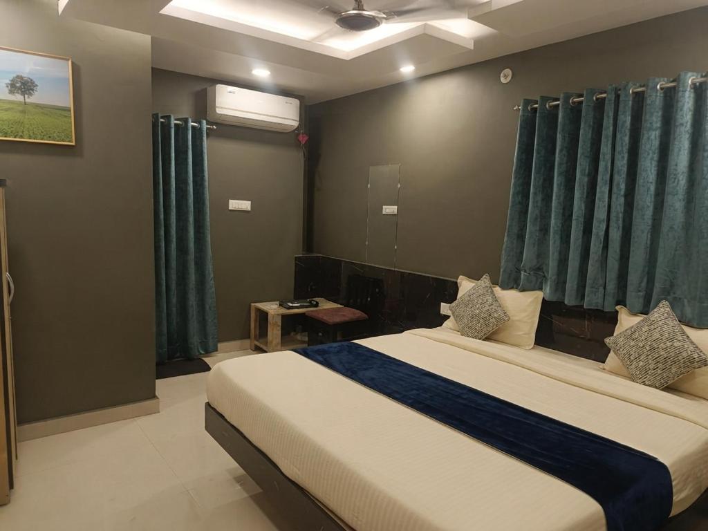 a bedroom with a large bed with blue curtains at FabHotels Divo in Chennai