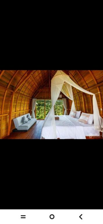 a bedroom with a large bed with mosquito nets at Suwehan Blue Ocean Cliff in Semarapura