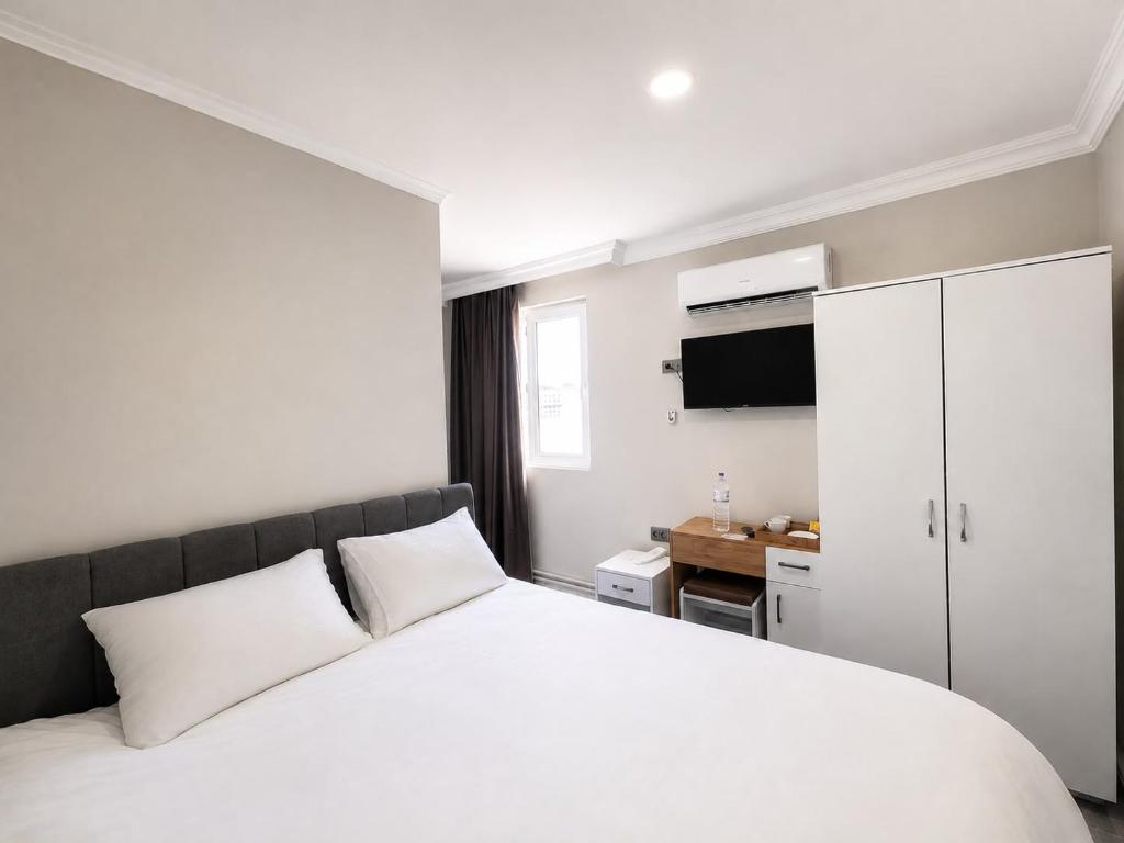 a bedroom with a white bed and a white cabinet at Stone Hotel Belek in Belek