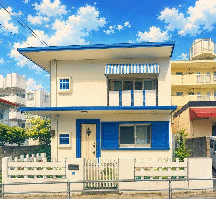 a blue and white house with a white fence at 浦添民泊ejuイージュ in Urazoe