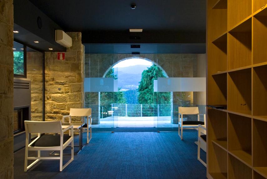 a dining room with a large window in a building at Grupo Izarbe, HOTEL ELLAURI in Zeanuri