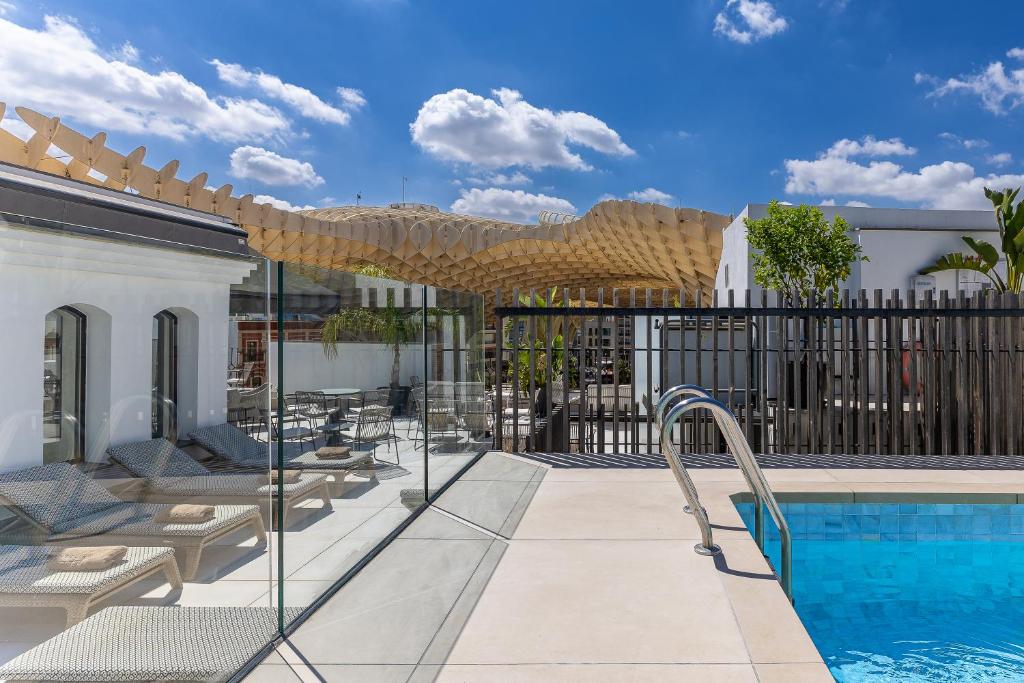 a patio with a swimming pool and a fence at Intelier Casa de Indias in Seville