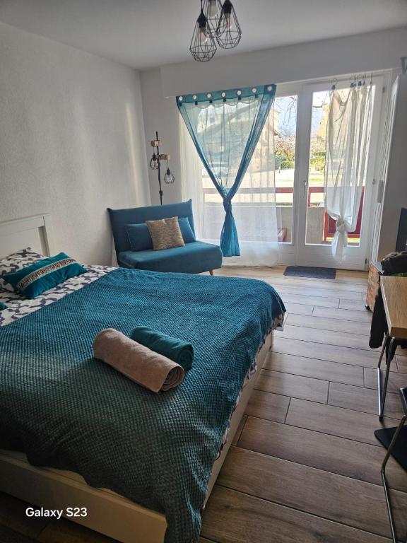 a bedroom with a bed and a chair and a window at La Douceur Epicée in Fully