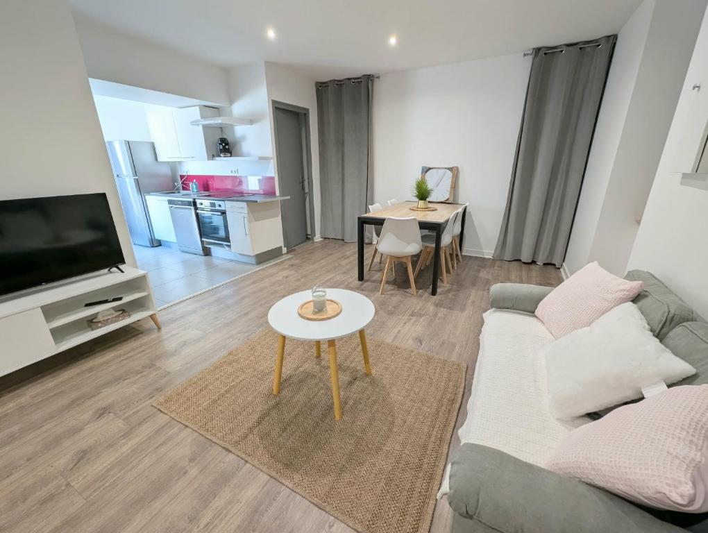 a living room with a couch and a table at Maison dans quartier calme proche centre-ville in Château-Gontier