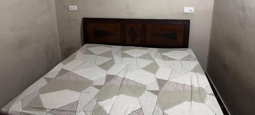 a small bedroom with a bed with a hexagonal sqor at Gokul Bhawan in Kedārnāth