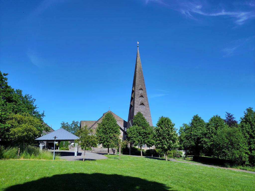 a church with a steeple in the middle of a field at Herbergskirche Gleidorf in Schmallenberg