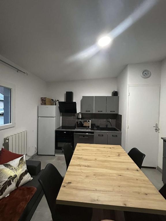 a living room with a table and a kitchen at appartement 4 pers,tout confort, randonnée, vélo, nature, visite in Laveissière