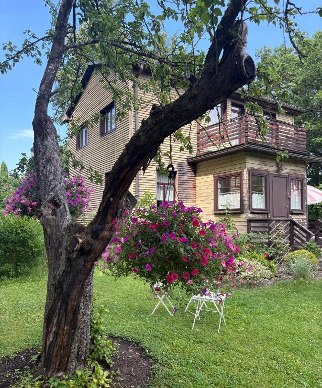 a house with a table and flowers in front of it at Vēsturiska privātmāja Ogres centrā in Ogre