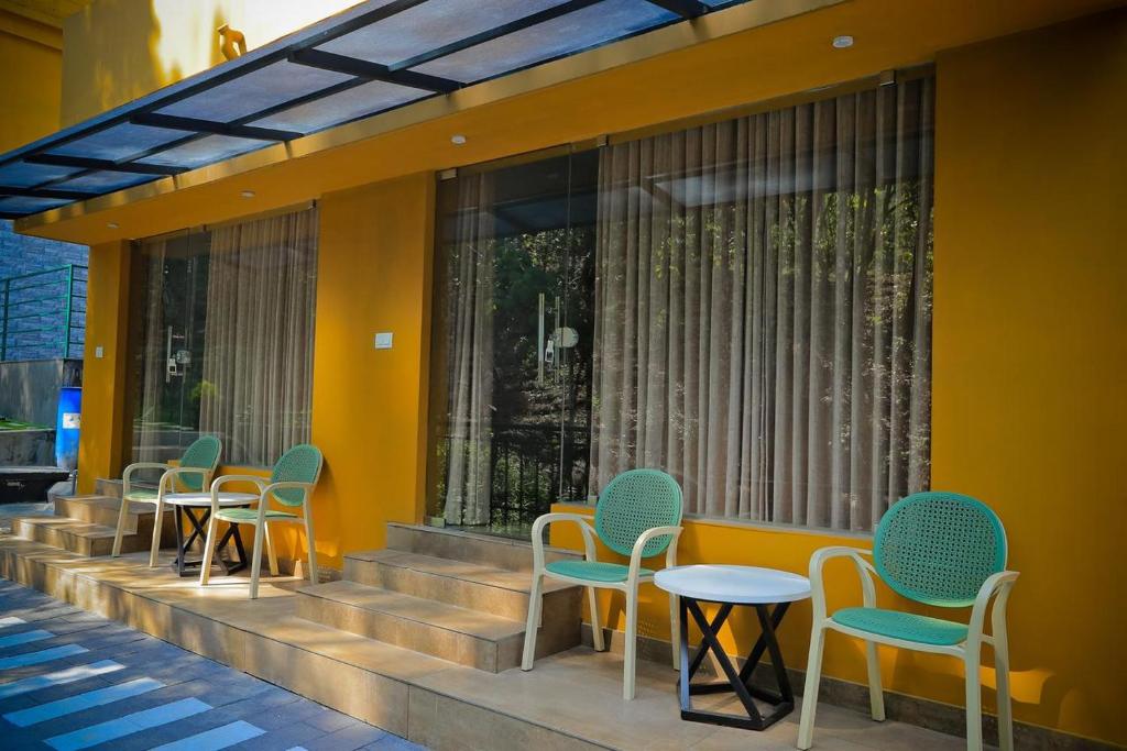 a row of chairs and tables on a building at Adrivana Hospitality By The Stream in Padinjarathara