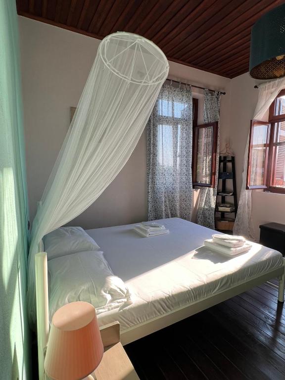 a bed with a mosquito net in a room at The Stone House in Maronia
