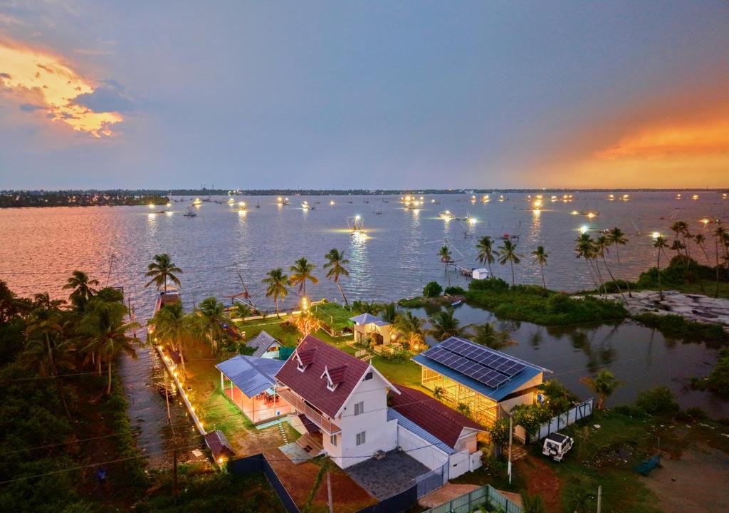 an aerial view of a house in the middle of a body of water at Celestiah Lakeshore Kochi by VOYE HOMES - Peaceful Backwater Stay in Kumbalangi in Cochin