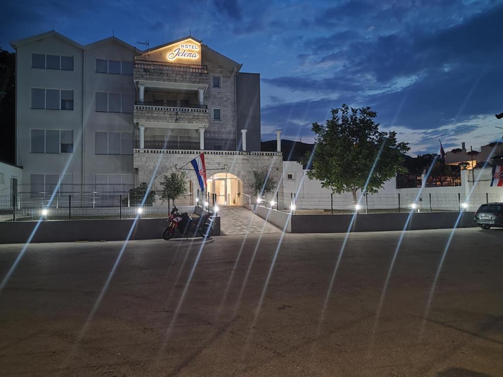 a building with a fountain in front of it at Hotel Jelena in Brnaze