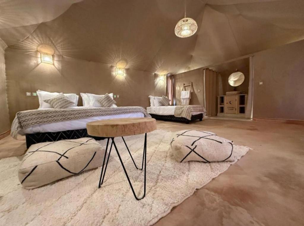 a large bedroom with two beds and a table at Sahara Legacy Camp in Merzouga
