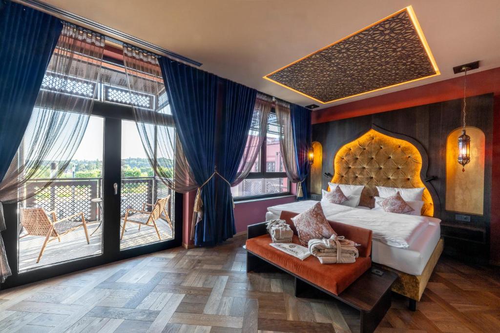a hotel room with a bed and a balcony at Le Marrakech Boutique Hotel in Kleinblittersdorf