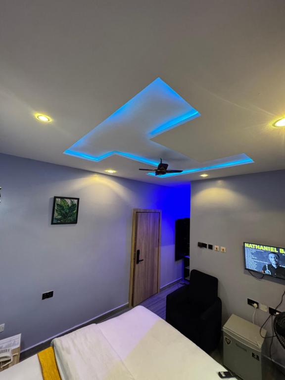 a bedroom with a bed and a ceiling with blue lights at Clisamnoris Hotel limited in Diobu