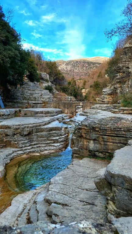 a rocky hillside with a pool of water at Archontiko Geki 1876 in Papingo