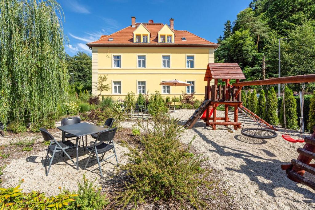 a backyard with a table and a playground at Villa Rathmannsdorf in Rathmannsdorf