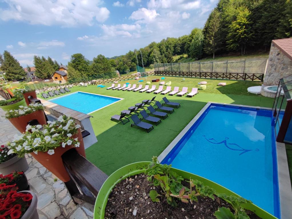 a resort with two pools and lounge chairs at Apartman Studio Lux u Kraljevim Čardacima in Kopaonik