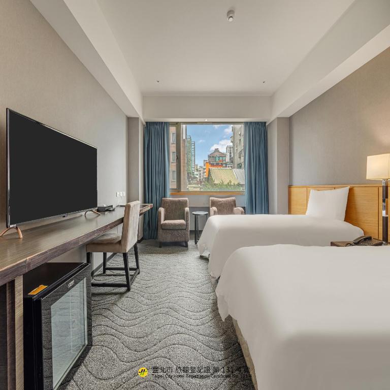 a hotel room with two beds and a flat screen tv at Guide Hotel Taipei Chongqing in Taipei