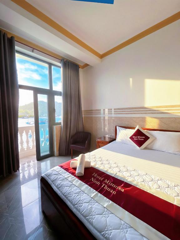 a hotel room with a bed and a large window at Mimosa 8 Hotel - Ninh Chử in Ninh Hải