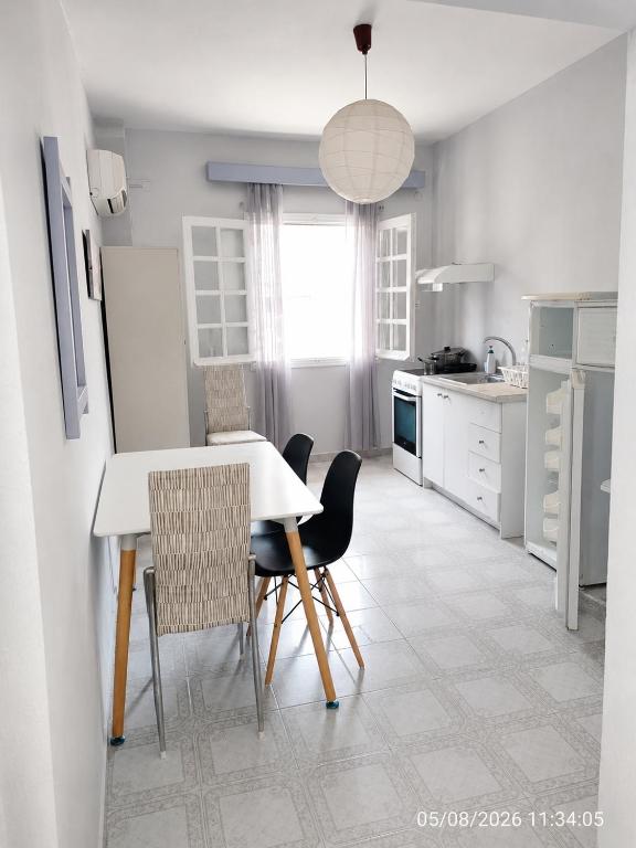 a kitchen with a white table and chairs at Galatas home in Galatas